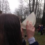 A girl using a paper plate to look through
