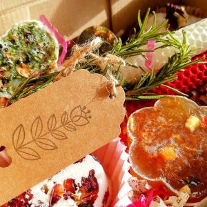 Box containing soaps, bath bombs and rolled beeswax candles.